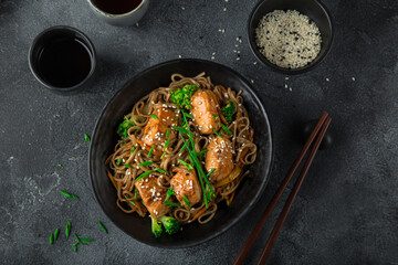 asian soba noodle and teriyaki salmon  in black bowl