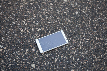 Phone with broken screen lying on the street