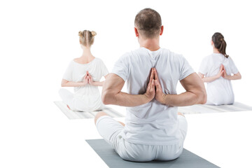 Back view of sporty young people sitting in lotus position with namaste mudra sign