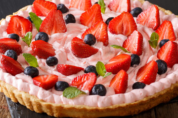 Sophistication tart with strawberries and blueberries with whipped cream close-up. horizontal