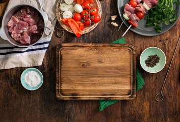 Kitchen board with shish kebab and various vegetables