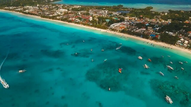 Aerial view of beautiful tropical island with white sand beach, hotels and tourists. Tropical lagoon with turquoise water and white sand. Beautiful sky, sea, beach, resort. Beautiful tropical beach of