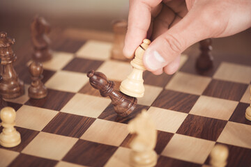 close up view of man playing wooden chess alone