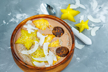 Chocolate smoothie bowl with exotic fruits and energy balls. Love for a healthy vegan food concept