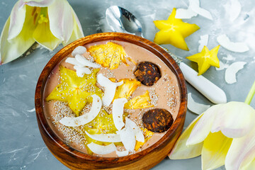 Chocolate smoothie bowl with exotic fruits and energy balls. Love for a healthy vegan food concept