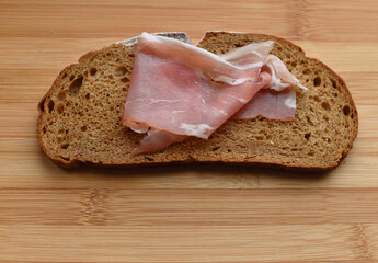 fresh bacon on a cutting Board on a piece of black bread