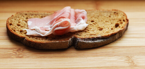 fresh bacon on a cutting Board on a piece of black bread