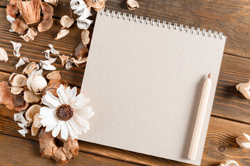 Blank notebook with flower on vintage wooden table