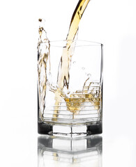 A glass of whiskey in which poured on a white background.
