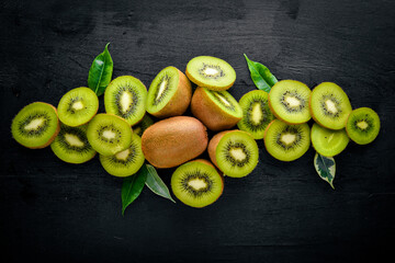 Kiwi fruits are on top of the black kitchen table. Top view with copy space.