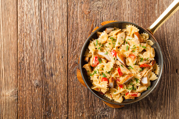 Pasta farfalle with chicken and paprika, in carbonara sauce.