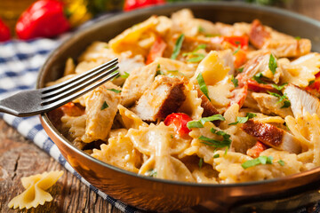 Pasta farfalle with chicken and paprika, in carbonara sauce.