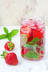 Fototapeta na wymiar Summer refreshing water with strawberries and mint