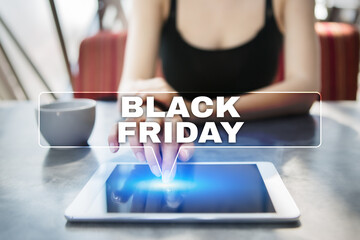 Woman using tablet pc and selecting black friday.