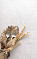 Cutlery, spoon and fork in old fabric on Wooden background. Top view. Free space.