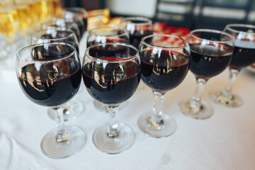 Many glasses of red wine in a row on the table