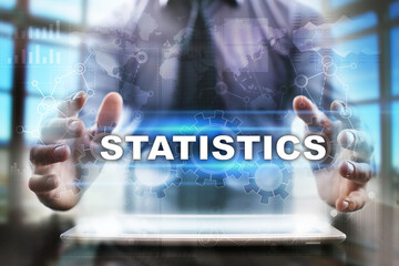 Fototapeta na wymiar Businessman using tablet pc and selecting statistics.