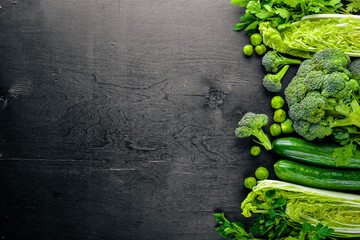 Collection of fresh green vegetables placed on black stone