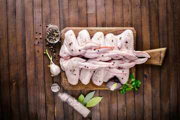 Raw chicken wings with spices. On Wooden surface. Top view.