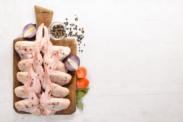 Raw chicken wings with spices. On Wooden surface. Top view.