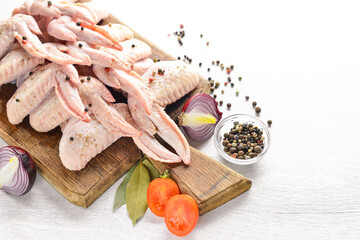 Raw chicken wings with spices. On Wooden surface. Top view.