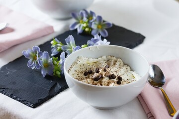 Sour cream mousse dessert sprinkled with chocolate and chocolate chips. Served on decorated table