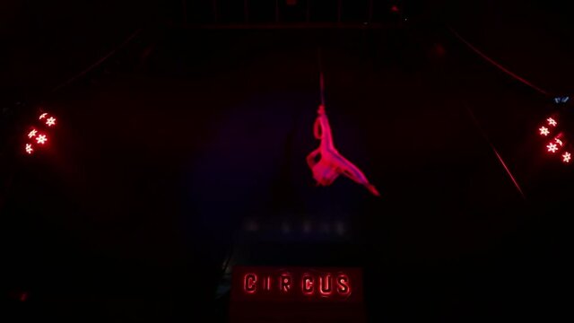 Air gymnast performs acrobatic stunts under the dome of the circus