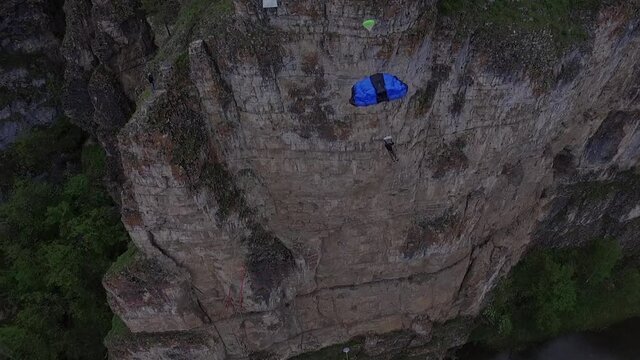 Base jumpers with high cliffs above the river. The Ural Mountains. Shooting from the air