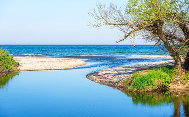 Small stream reaches the sea and freshwater flow through the river mouth. Havang nature reserve in...