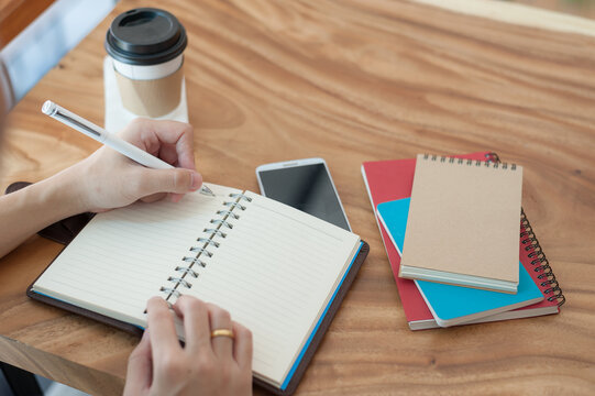 Asian man writing text on notebook