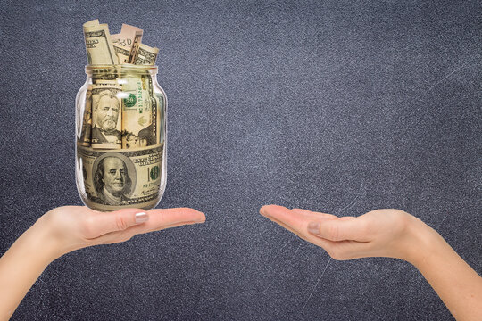 Female Hand Holding Glass Jar With Money