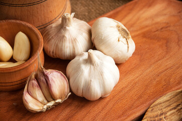 Garlic on cutting board , close-up on sacking. burlap background