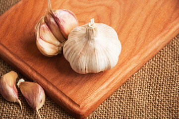 Garlic on cutting board , close-up on sacking. burlap background Copy space. Space for text.