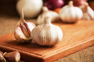 Garlic on cutting board , close-up on sacking. burlap background Copy space. Space for text.
