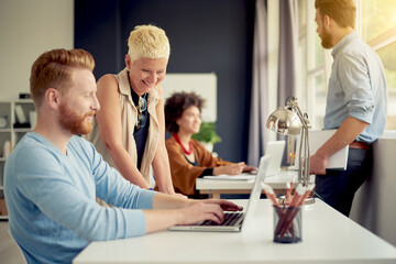 Caucasian businesswoman giving advice to her colleague while standing in modern office