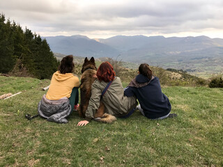 Fototapeta na wymiar happy family mother, two daughters and dog pet looking panorama on the hills