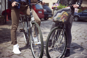 Low section of couple standing with bicycles on street