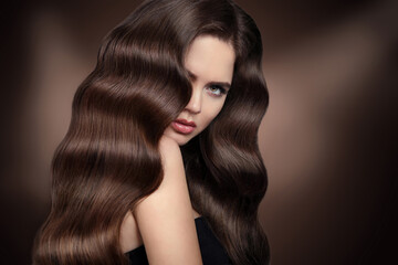 Healhy hair. Beautiful girl with Wavy hairstyle. Beauty woman portrait. Brunette model with shiny...