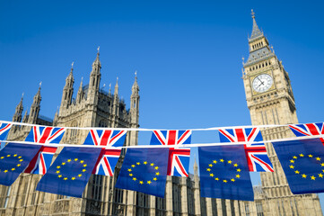 Fototapeta na wymiar European Union and United Kingdom flag Brexit bunting hanging together in front of Big Ben and the Houses of Parliament at Westminster Palace