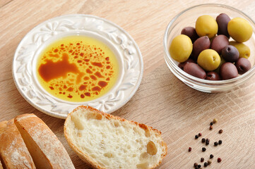 fresh bread, cut into slices with olives and olive oil with balsamic vinegar in a bowl