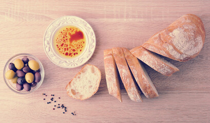 fresh bread, cut into slices with olives and olive oil with balsamic vinegar in a bowl