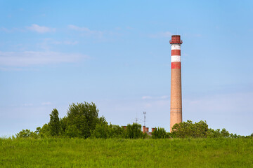 Fototapeta na wymiar Power station chimney in the green