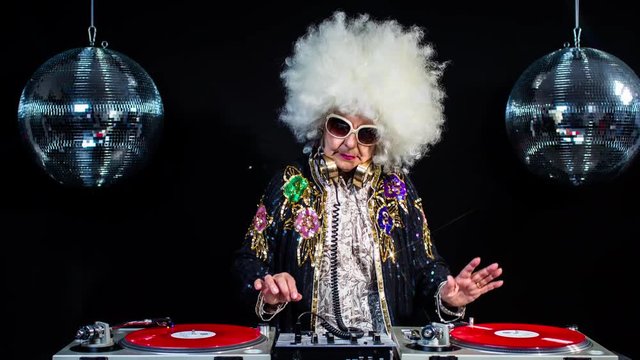 amazing DJ grandma, older lady djing and partying in a disco setting. these retired rockers will get the party going