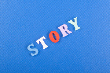 STORY word on blue background composed from colorful abc alphabet block wooden letters, copy space for ad text. Learning english concept.
