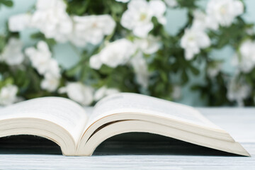Open hardback book on wooden table and natural background. Back to school. Copy space for ad text.