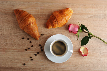 morning Breakfast - two croissants, coffee and red rose with torn petals