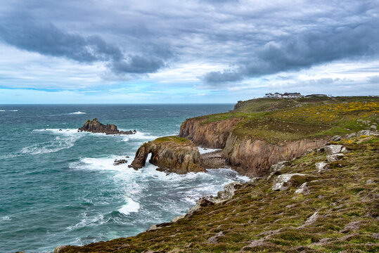 Enys Dodman, a rock arch about 1km south of Lands End, The Armed Knight can be seen beyond.