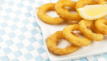 Plate of squid a la romana on white and blue tablecloths. Food squids.