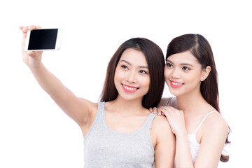 Two Pretty Young Girls Taking Selfie Photos. Isolated on White Background.