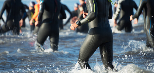 Triathletes running out of the water on triathlon race